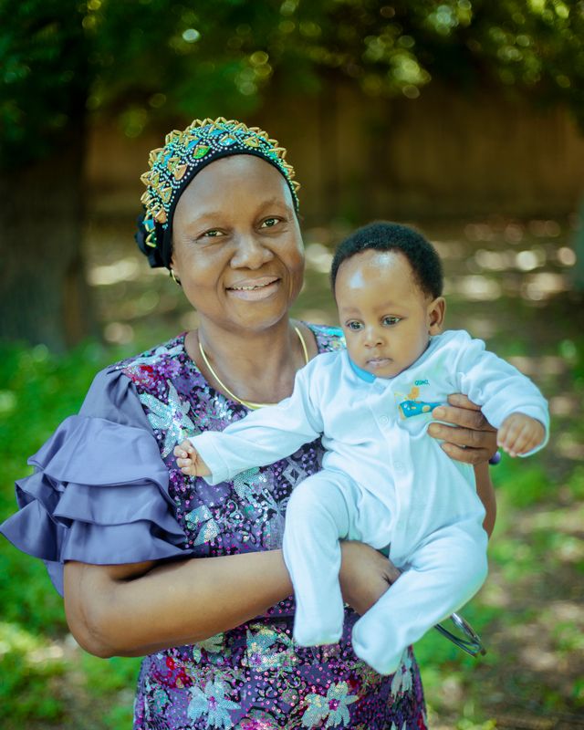 Grandmother Holding Baby Outdoors in Sunlight