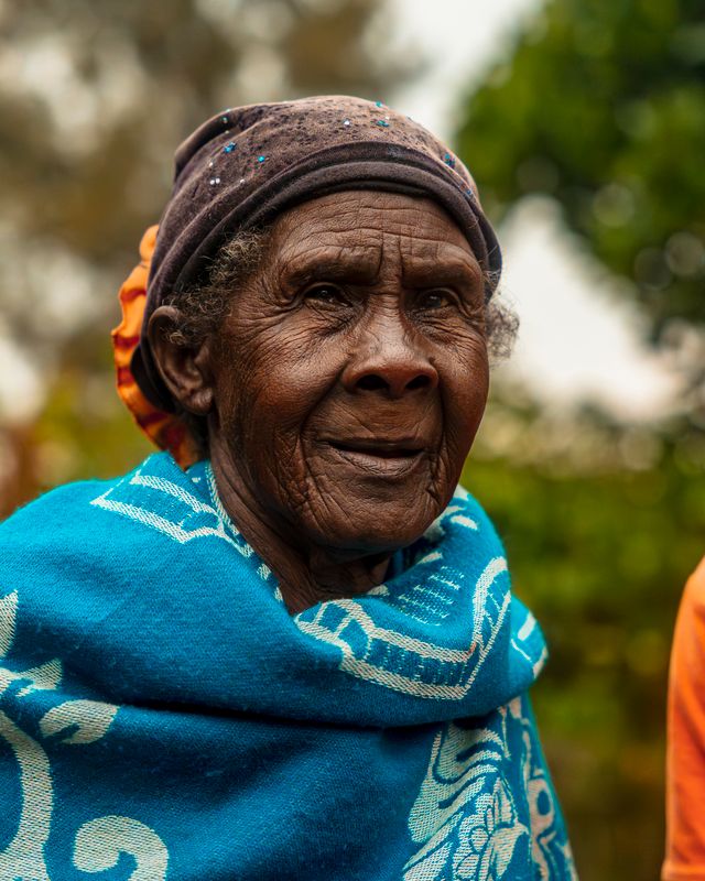 Elderly Woman in Colorful African Attire Outdoors