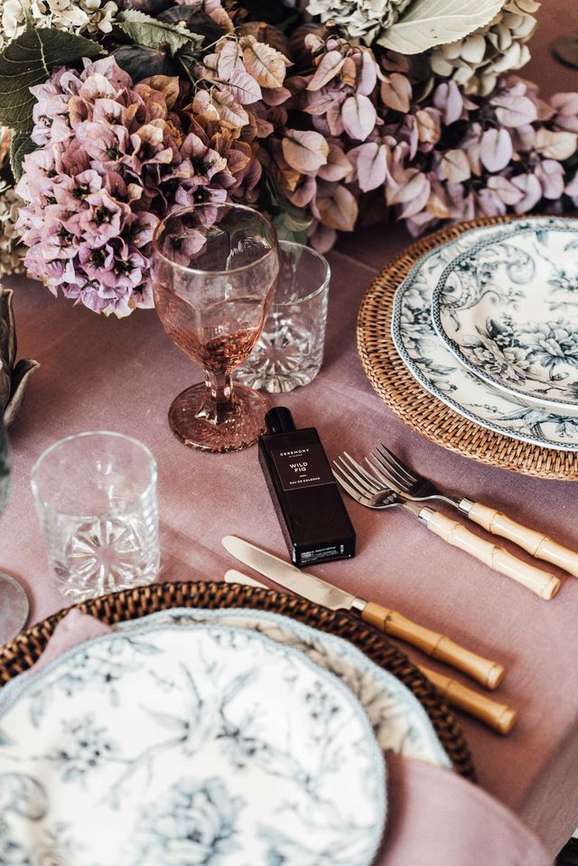 Banquet table with tableware and blooming flowers